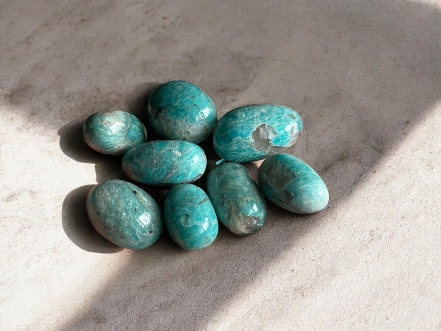 Amazonite tumbled crystals on a concrete