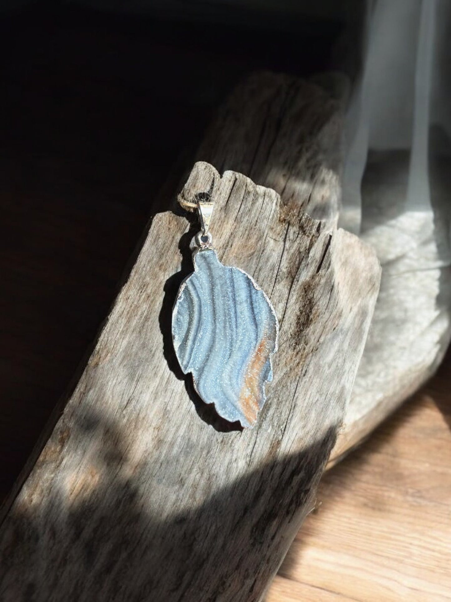 Druzy agate leaf crystal pendant on wood