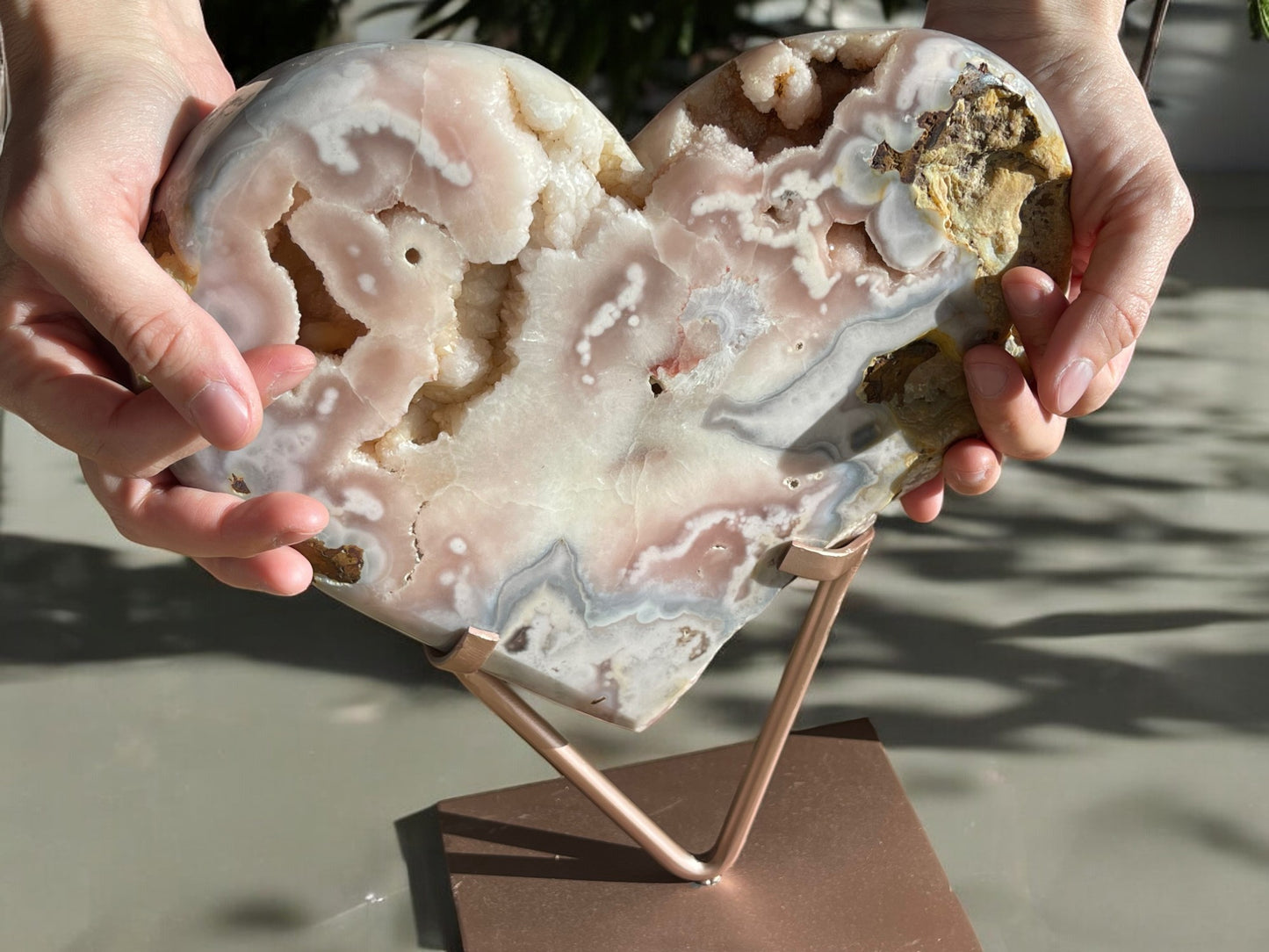 Hands holding pink amethyst crystal heart