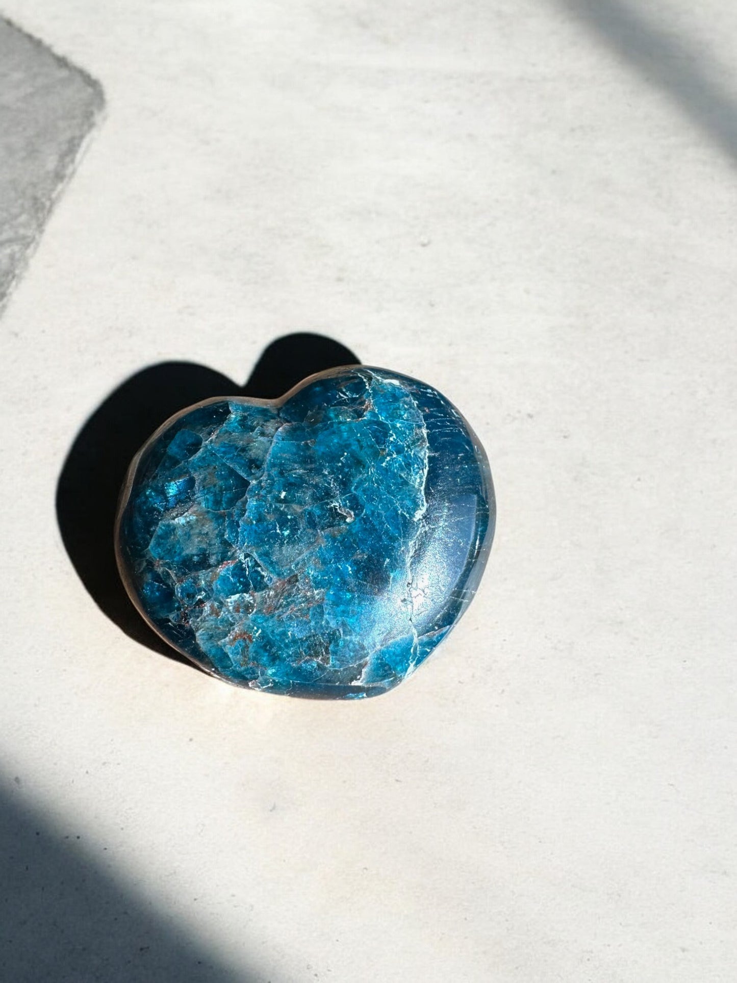 Blue apatite crystal heart in sunlight