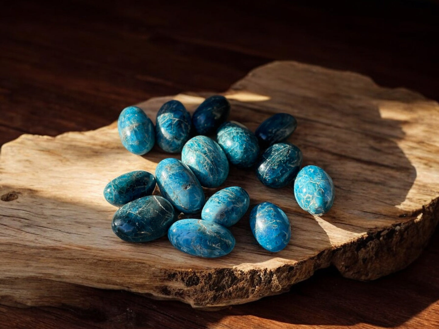 Blue apatite tumbled crystals on a slab