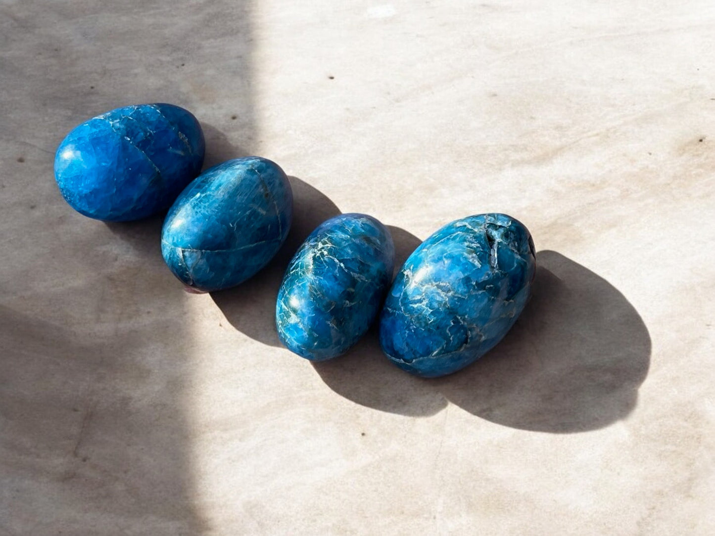 Blue apatite tumbled crystals on concrete