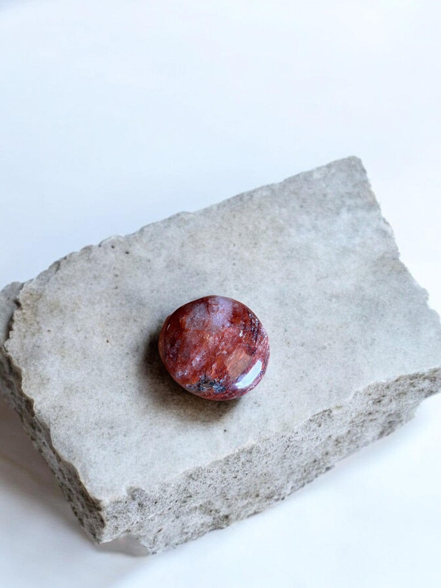 Fire quartz palm stone on a rock