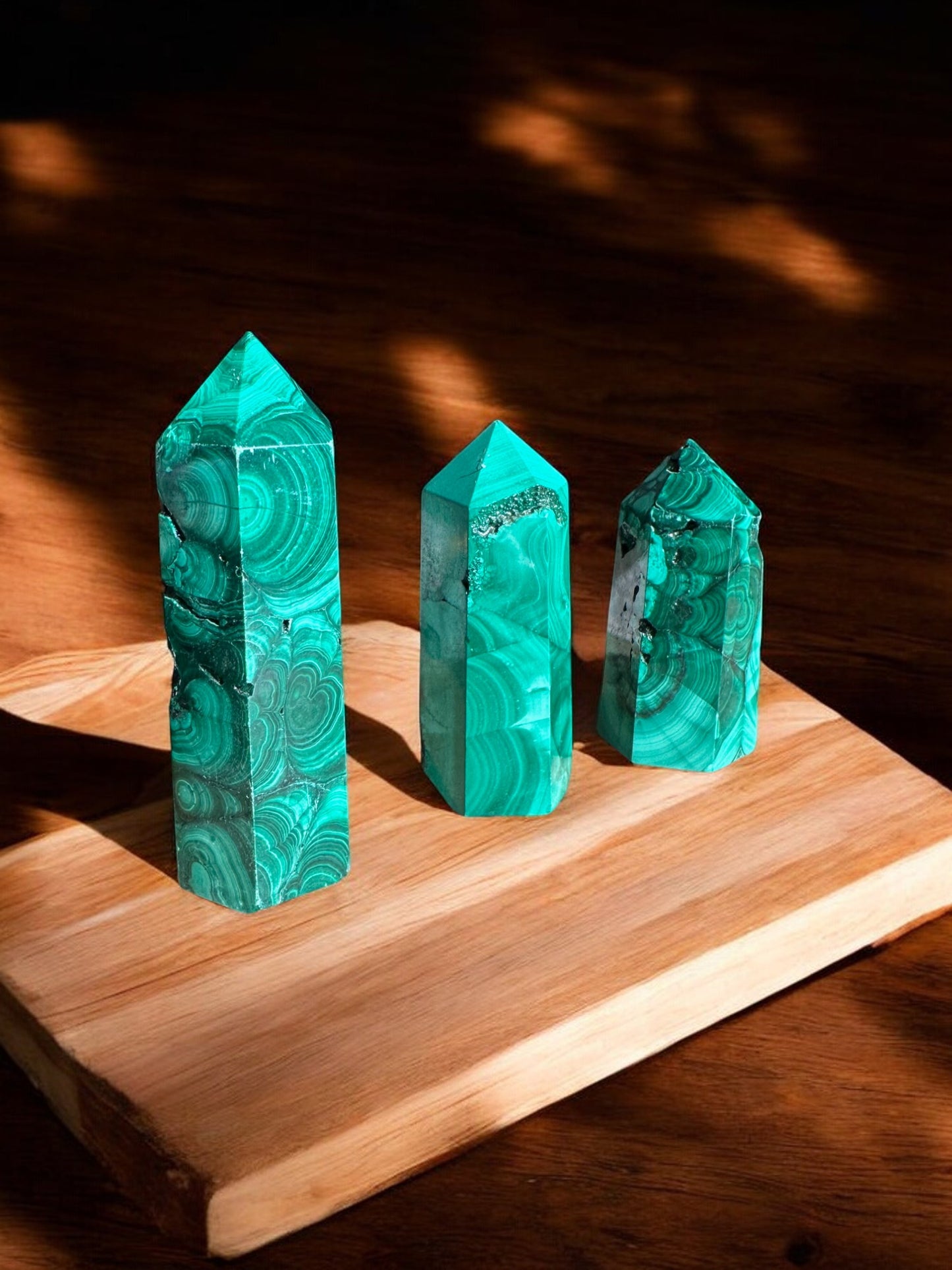 Malachite crystal towers on wooden slab