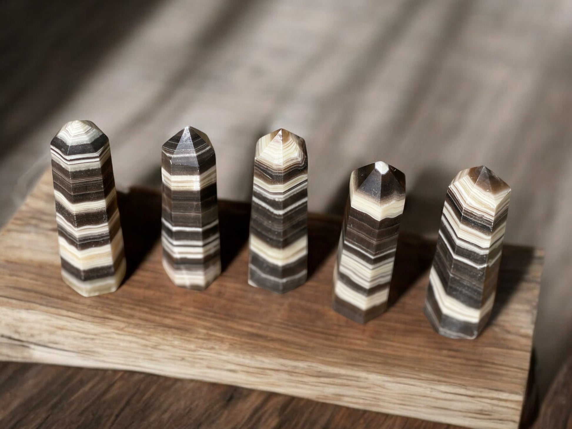 Zebra calcite crystal towers on wooden slab